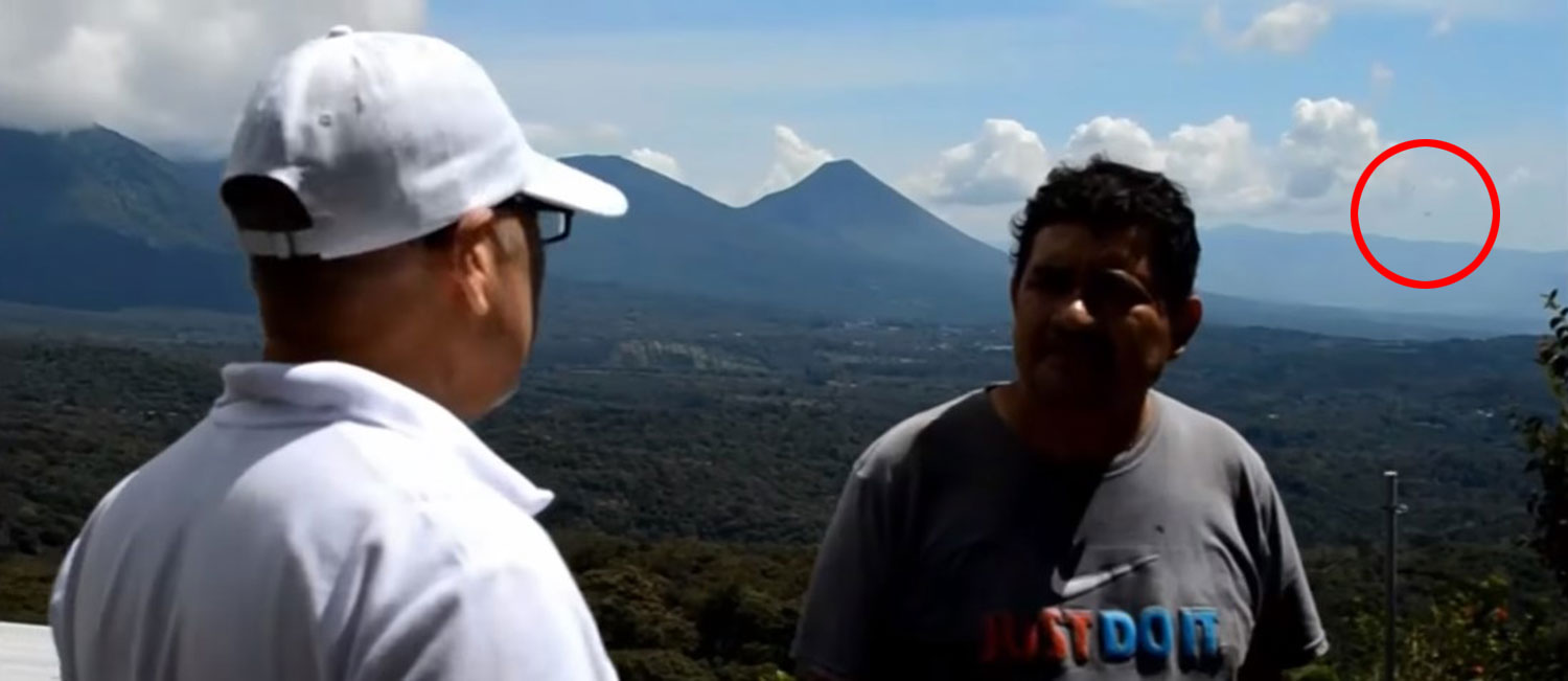 The UFO (circled) showing up in the background during an interview about UFOs with expert.