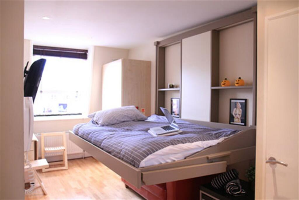 The pokey studio flat available for renting in Notting Hill, London. Interior (showing the bed down)