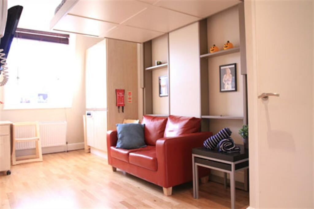 The pokey studio flat available for renting in Notting Hill, London. Interior (showing the bed hidden away).