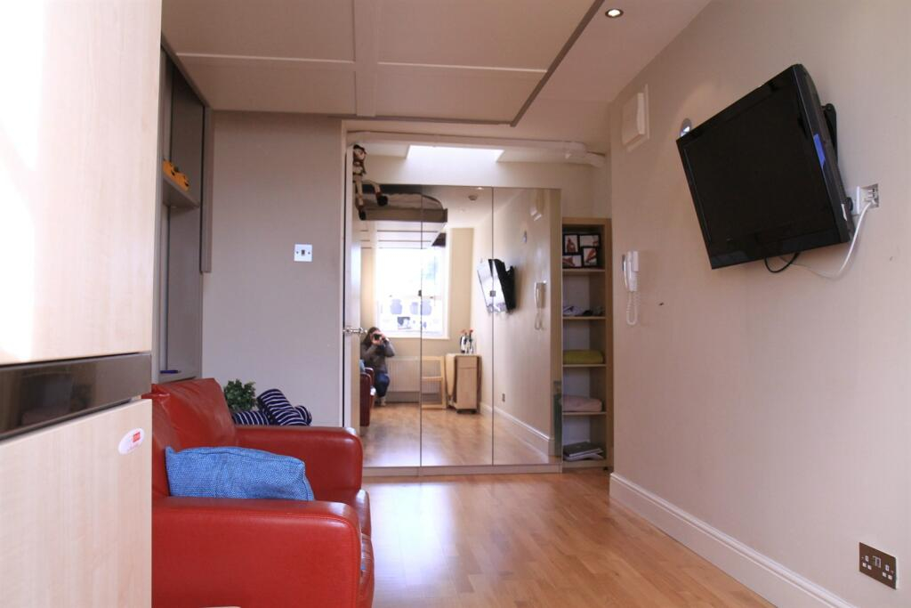 The pokey studio flat available for renting in Notting Hill, London. Interior (showing the bed hidden away).