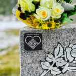 A Turning Hearts QR code medallion attached to a gravestone.