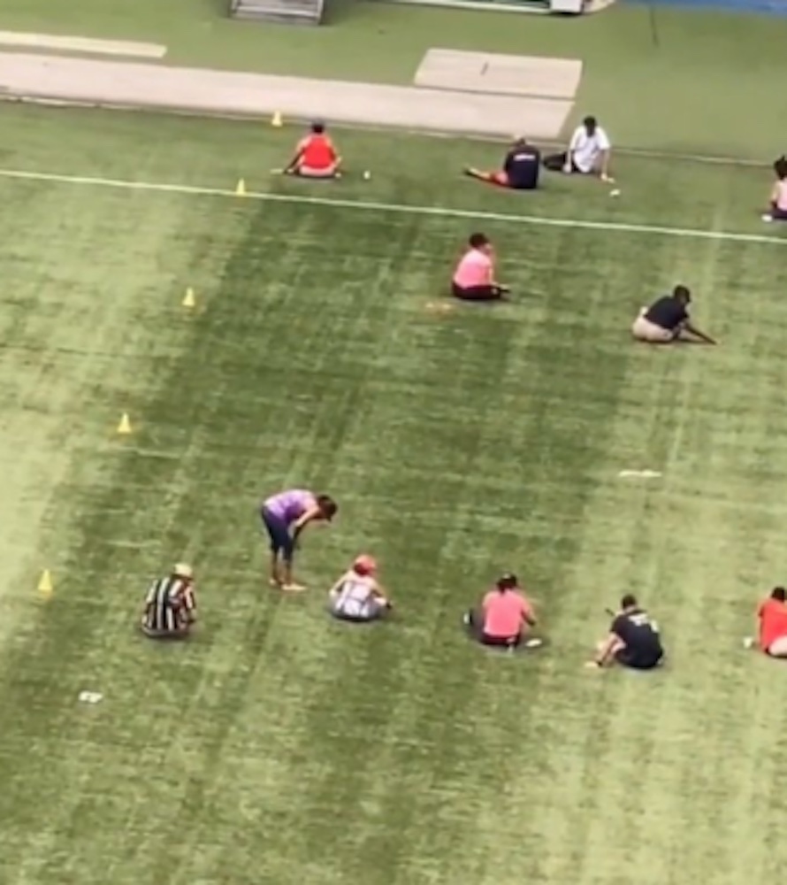 video picture of the workers individually picking up bracelet beads from the football pitch after a Taylor Swift concert.