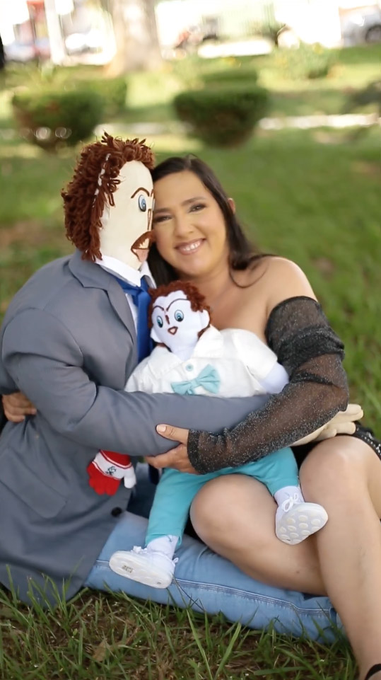 Meirivone in a park with her rag doll husband and baby.