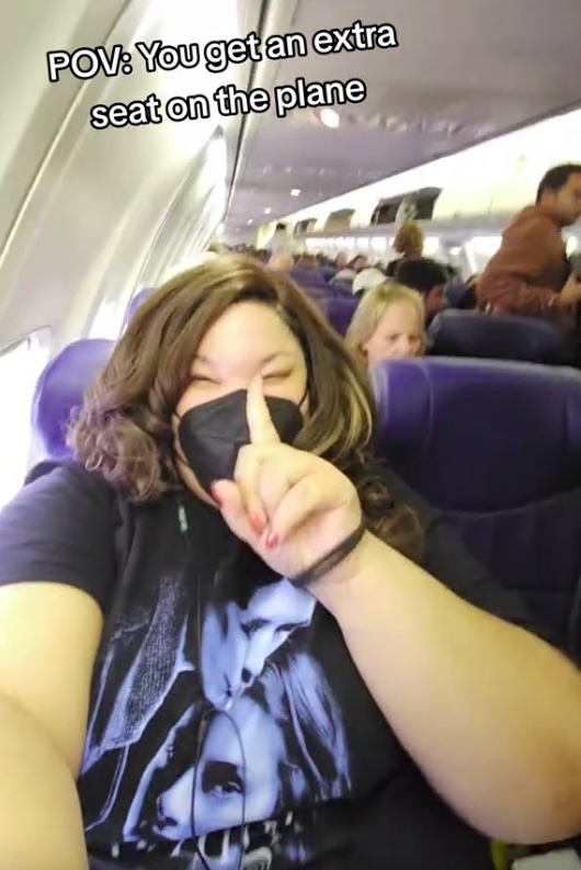 A video grab of Saibra taking over an extra seat on the plane as a plus-size traveller.