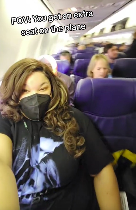 A video grab of Saibra taking over an extra seat on the plane as a plus-size traveller.
