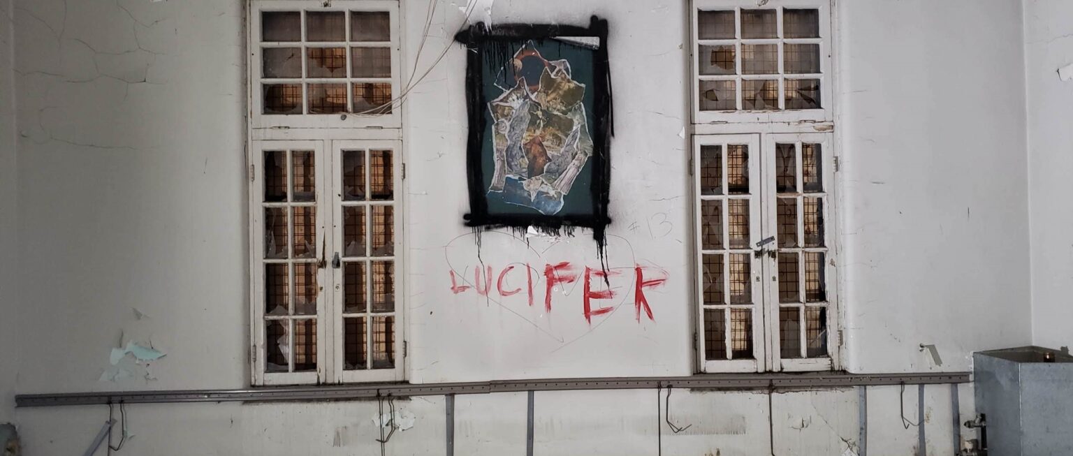 ‘Lucifer’ painted on the wall, in what is seen as blood inside the abandoned asylum discovered by urban explorer in Ontario, Canada.