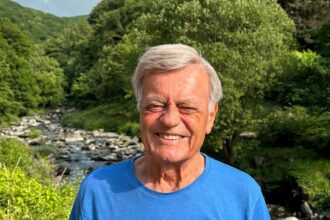 Fuming after hitting potholes, Tony Blackburn replaces THREE car tyres. The radio legend criticizes the state of UK roads, asking when action will be taken.