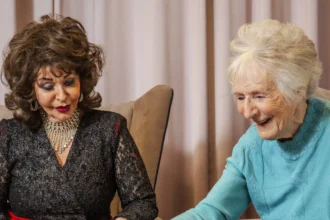 Heartwarming moment as King Charles and Dolly Parton lookalike's visit pensioners in care home.