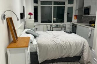 inside the studio flat in Harrow-on-the-Hill, London, offers a unique living arrangement with the oven positioned at the bottom of the bed, sparking humorous reactions online.