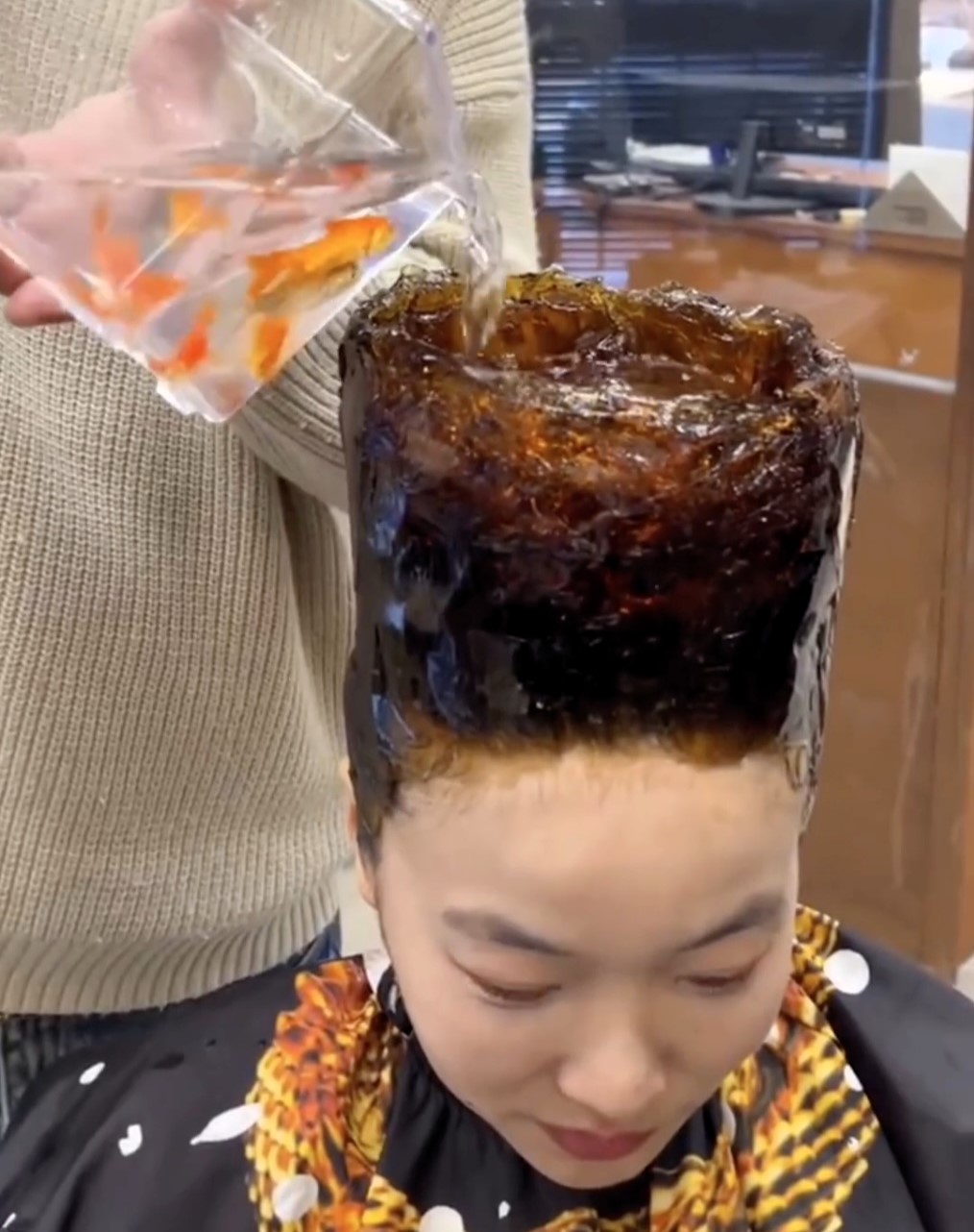 A daring woman in China gets a bold haircut, with her hair fashioned into a tall bowl and live goldfish poured into the hollow. The unusual style, done by hairstylist Lao Qiao, sparks mixed reactions online, with some finding it creative while others criticize it as cruel.
