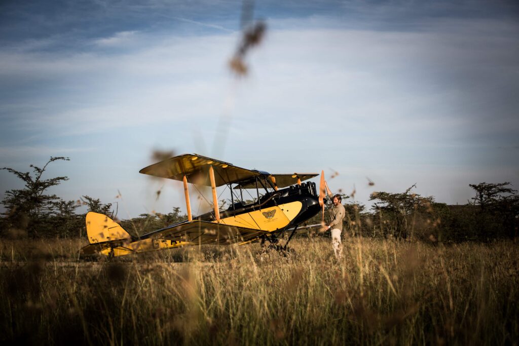 A vintage biplane from the movie "Out of Africa" sells for £416,000, soaring past its expected price. All proceeds support a new rhino sanctuary in Kenya.