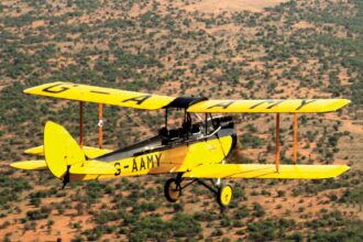 A vintage biplane from the movie "Out of Africa" sells for £416,000, soaring past its expected price. All proceeds support a new rhino sanctuary in Kenya.