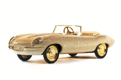A half-sized 24-carat gold E-Type Jaguar covered in Swarovski crystals sells for £3,000, a fraction of its estimated value, but it's a pedal-powered kids' toy, not a full-size car.