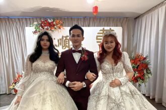 A man's unconventional wedding to two brides sparks controversy in Kuching, Malaysia. Lim Soon Kian's celebration faces legal scrutiny, potentially facing charges for bigamy amid uncertainty over the marriage's official status.