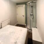 Basement Flat in Bristol Dubbed 'Prison Cell' with Shower Next to Bed Sparks Outrage Online. Hefty £1,550/Month Rent Stuns Viewers.