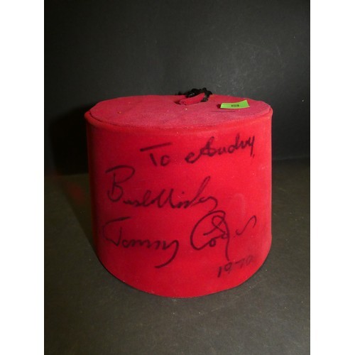 A signed Tommy Cooper fez fetched £62 at auction, sparking a hilarious bidding war reminiscent of the comedian's skits. The auctioneer's quips, including Cooper's catchphrase "Just like that," added to the comedic atmosphere. Cooper's iconic fez, borrowed from a waiter during a Cairo performance, became his trademark, immortalizing his legacy in comedy despite his sudden passing in 1984.