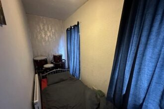 A Welsh terraced house with a surprising feature - a tiny bedroom likened to Harry Potter's cupboard under the stairs - goes viral online. Despite limited space, the property offers a large living room, kitchen, and more, but Reddit users question its two-bedroom classification.