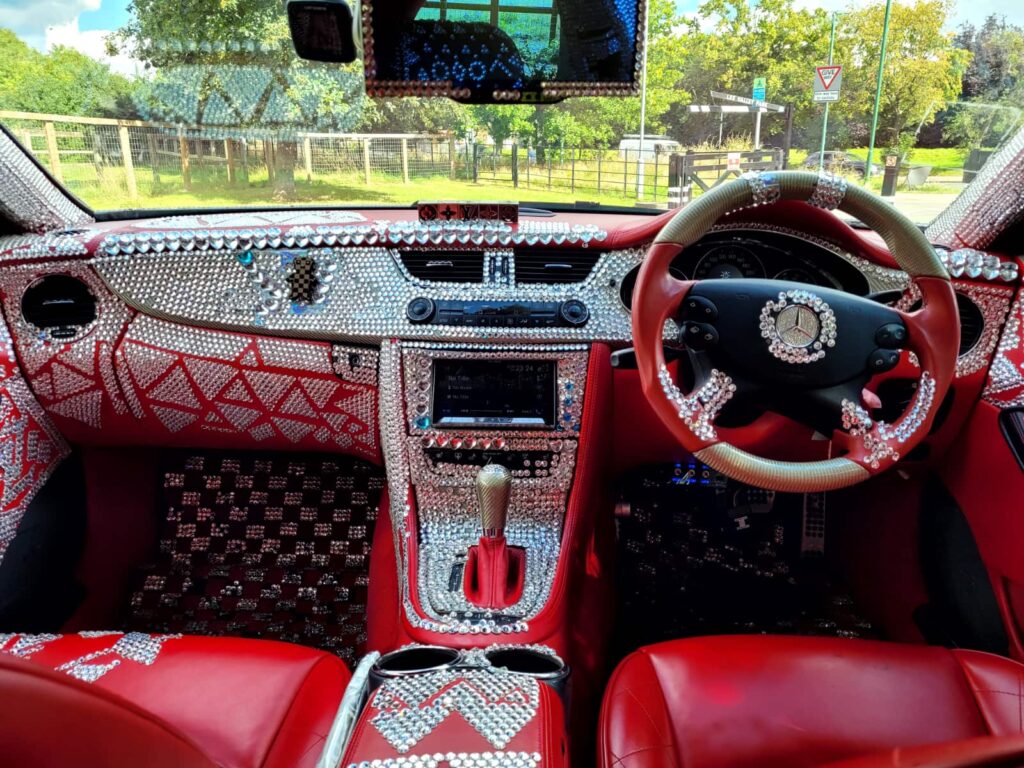 A crystal-covered 2005 Mercedes CLS500, perfect for weddings, is on sale for £7,000. With just 34,000 miles, it boasts bling both inside and out, complete with a red leather interior and built-in DVD player. Despite mixed reactions, it's a unique find!