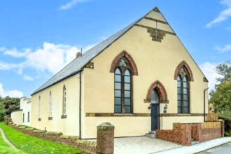 A former Moorsholm Methodist Church in the village of Moorsholm, near Redcar, North Yorkshire, transformed into a modern, four-bedroom house with a pool table and roof terrace. Open-plan living, en-suite bedrooms, and a projected annual income for holiday lets. Listed for £525,000 with Bradley Hall estate agents.