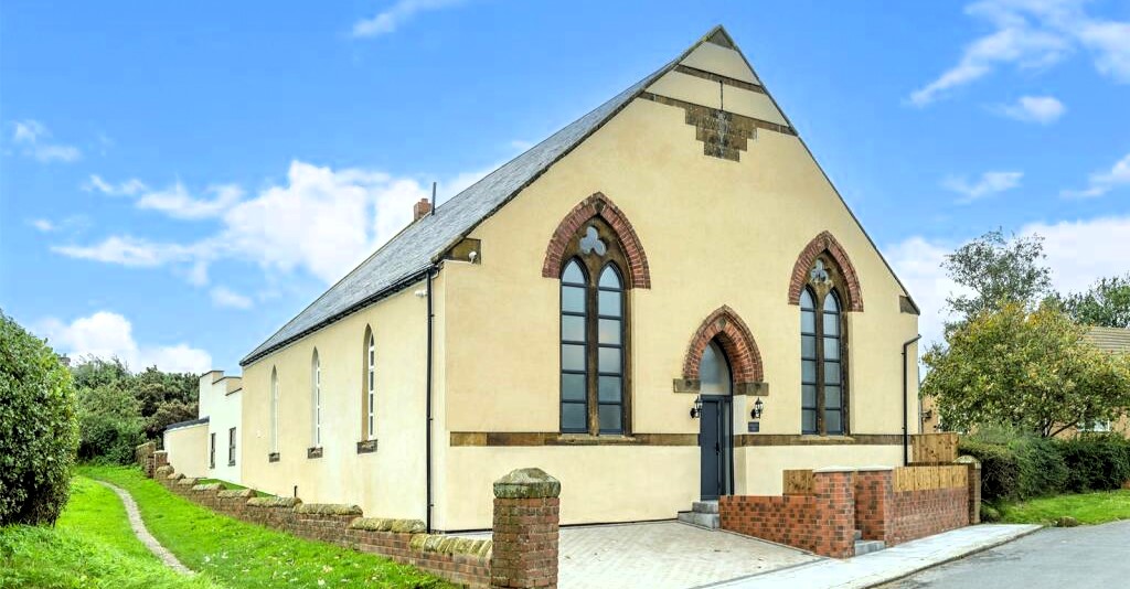 A former Moorsholm Methodist Church in the village of Moorsholm, near Redcar, North Yorkshire, transformed into a modern, four-bedroom house with a pool table and roof terrace. Open-plan living, en-suite bedrooms, and a projected annual income for holiday lets. Listed for £525,000 with Bradley Hall estate agents.