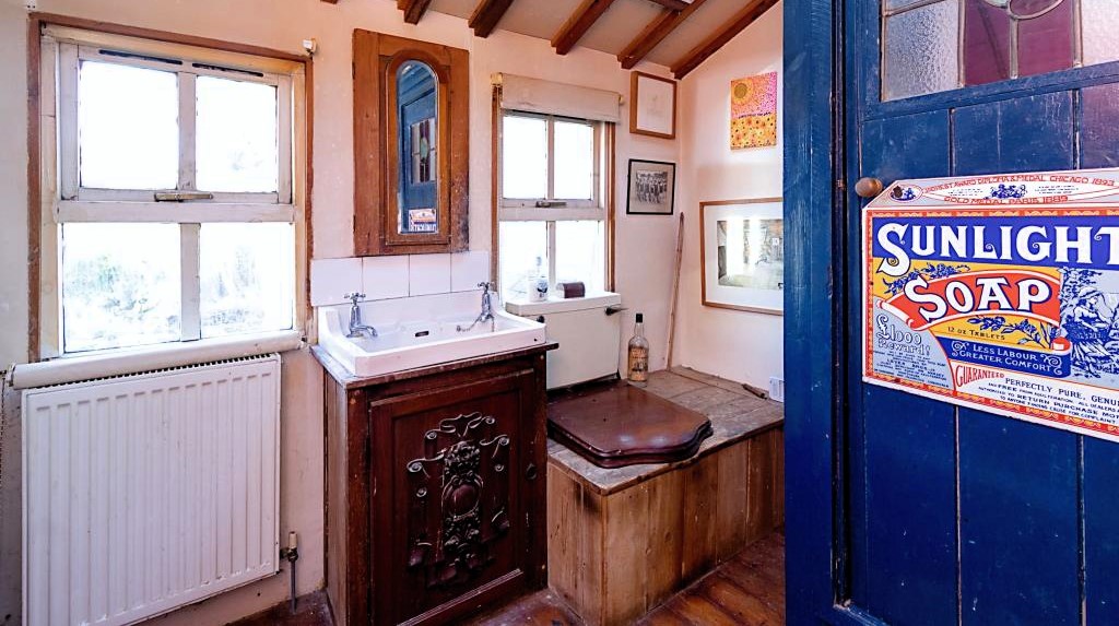 Newquay cottage, priced at £135,000, stirs online buzz with its quirky features like a Tardis-like blue shower and vintage wooden box toilet. Perfect for Doctor Who fans or those seeking characterful homes. Ideal for first-time buyers, needs refurbishment. Listed by What's The Jam.