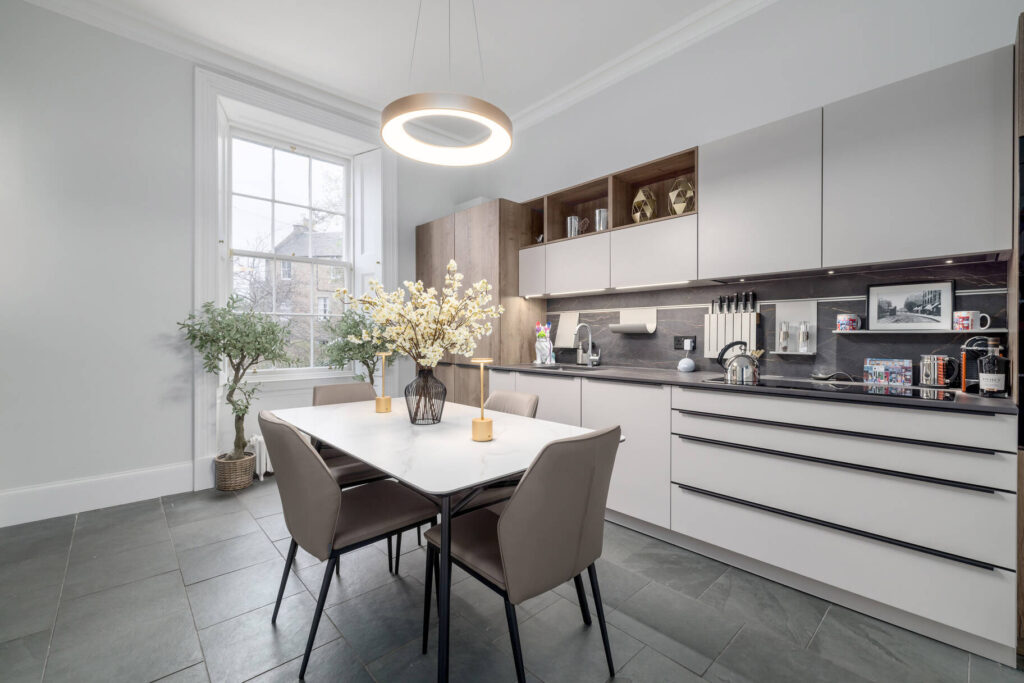 Unassuming shopfront conceals luxurious Georgian townhouse in Stockbridge, Edinburgh. Priced at £1.2m, it boasts 4 bedrooms, 2 bathrooms, elegant décor, and a private garden. Listed by Murray & Currie.