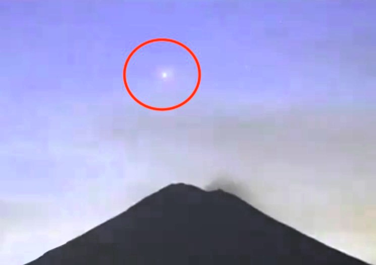 A mysterious glowing light descends into a smoking crater at Mexico's Popocatepetl volcano, captured on camera. Could it be an inter-dimensional portal?