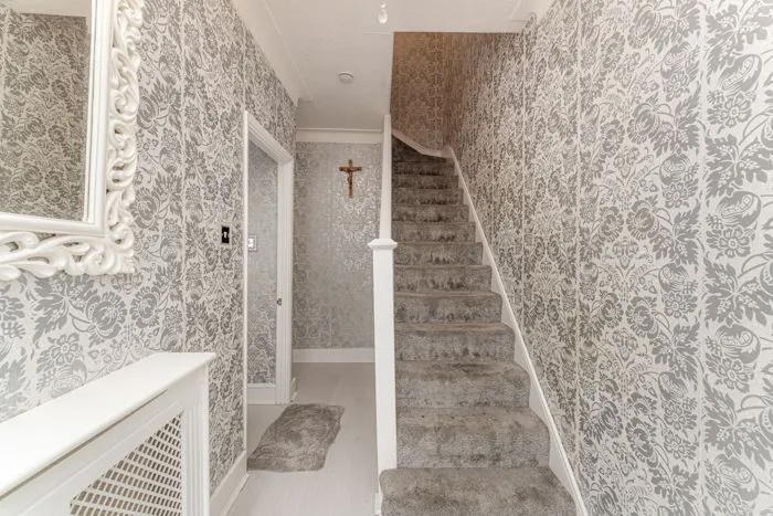 A north London terraced house with a unique grey velvet interior has been dubbed 'migraine-chic' by online critics, drawing attention for its dizzying wallpaper and bold color choices.