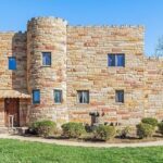 A castle-like house with its own moat in Charlestown, Indiana, has amazed online users with its low price of $425,000. Boasting fairytale finishes and woodwork, this 1990-built property offers 5 bedrooms, 3 bathrooms, and a charming wood shop, all set on a 1.25-acre lot.