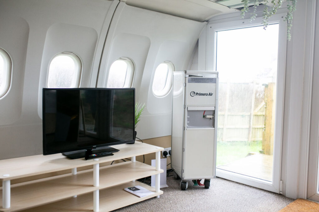 Experience luxury in a former Etihad airplane converted into a unique staycation spot in Tenby, West Wales. Fuselage bedrooms, cockpit-style kitchen, and outdoor seating await.