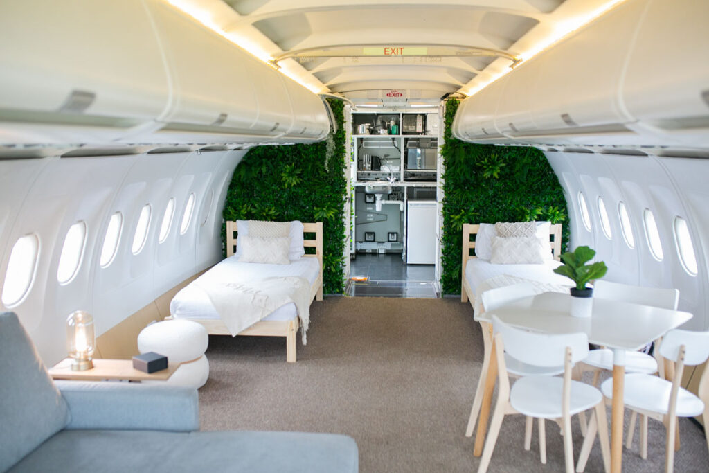 Experience luxury in a former Etihad airplane converted into a unique staycation spot in Tenby, West Wales. Fuselage bedrooms, cockpit-style kitchen, and outdoor seating await.