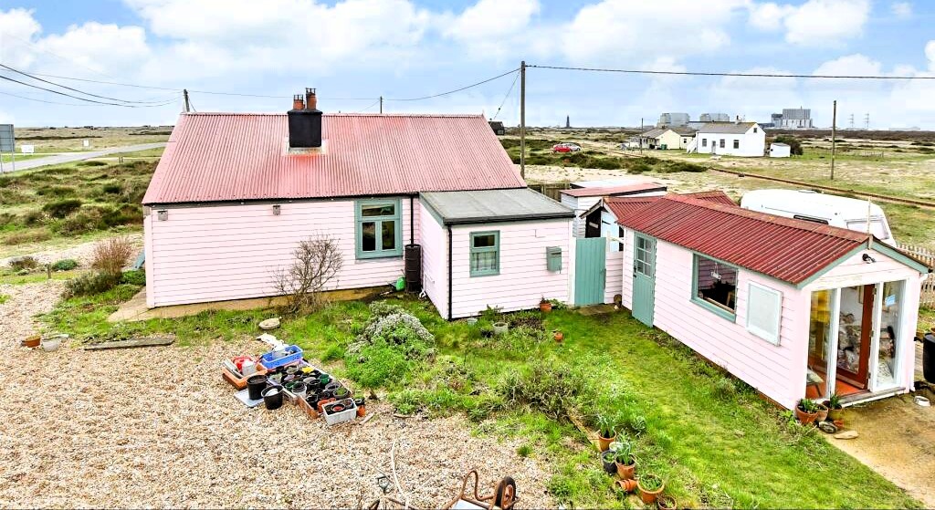 Own a detached bungalow in Britain's only desert, Dungeness, with stunning views and quirky charm. Experience isolation and atmosphere for £875k.