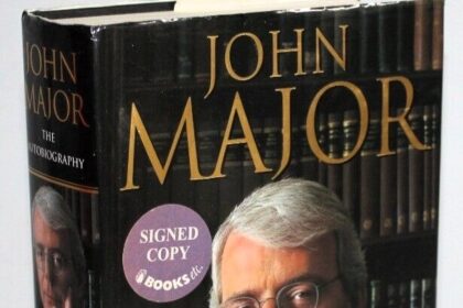 In a charity auction, a signed copy of Sir John Major’s autobiography sells for just £13.50, cheaper than its retail price, marking an unexpected turn.