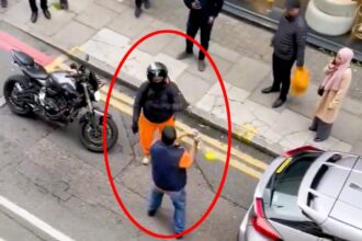 A road rage incident turned violent as a motorist swung a steering wheel lock at a motorcyclist, leading to a retaliatory punch and bystander intervention in Whitechapel, London.