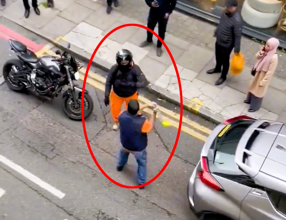 A road rage incident turned violent as a motorist swung a steering wheel lock at a motorcyclist, leading to a retaliatory punch and bystander intervention in Whitechapel, London.