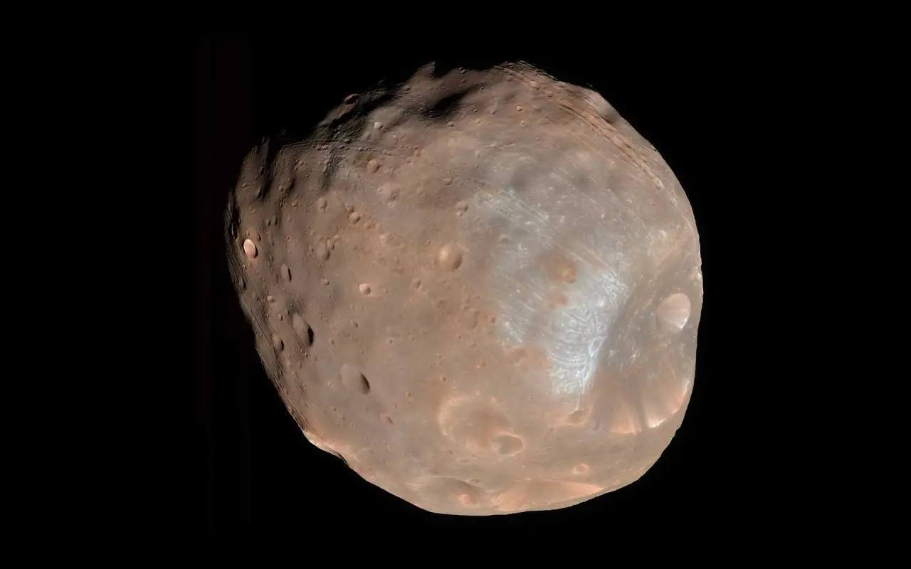 Phobos, Mars' "space potato" moon, is on a collision course with the Red Planet, set to crash in 50 million years. Its lumpy shape and viral image spark online jokes.