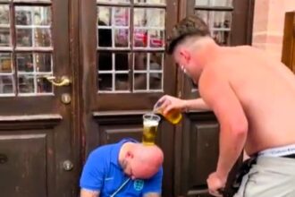 England fans entertain themselves by balancing a beer cup on a sleeping supporter’s head in Frankfurt, calling it more exciting than the dull 1-1 draw against Denmark.