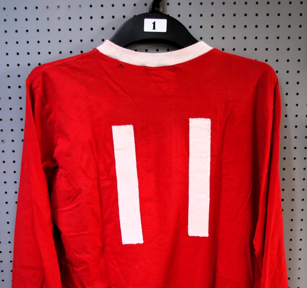 George Best's 1967-68 Manchester United shirt, worn during his peak season, sells for £13,300 despite a hole. Includes match programs, shorts, and memorabilia from his career.