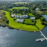 Luxury Hamptons compound with 24 bedrooms, 38 bathrooms, indoor basketball court, and 750-gallon shark tank listed for £77.8m ($99.5M). Stunning ocean views and amenities.
