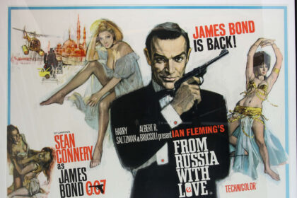 James Bond fans bid on 518 items at a 007 auction, with memorabilia like a From Russia With Love poster fetching £9,100. The auction in Woking raised over £30,000.