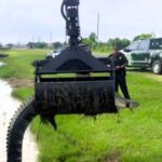Cops use a grapple truck to relocate a 12ft alligator from a drainage ditch in Monte Belvieu, Texas. Team effort ensures safe removal of the giant reptile.
