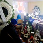 Mourners watch a live football match next to Grandpa Feña's open coffin at his wake in Chile. The passionate sports fan's funeral coincided with the Copa America.