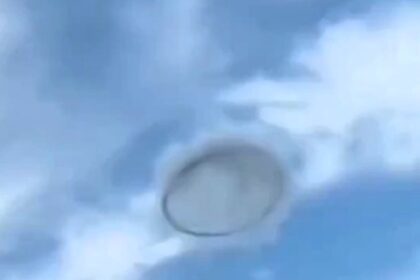 Mysterious 'ring' UFO spotted in broad daylight over Valencia, Venezuela, stuns locals. While some claim it's an alien visit, others suggest it's smoke from industrial sources.