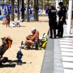 Holiday-goer warns of police clamping down on beach drinking in Benidorm. Viral video shows tourists fined for drinking wine, highlighting strict enforcement.