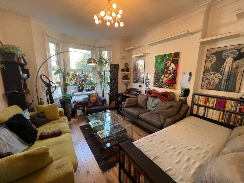 London living room sublet ad written by cats offers a single bed for £1,000/month. Shared space with Siamese cats and owners, baffling online viewers with its quirkiness.