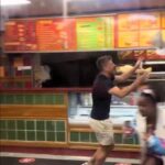 A seagull caused chaos in a Swansea fried chicken shop, flying around customers until a man in khaki shorts calmly caught it and released it outside, amusing onlookers.