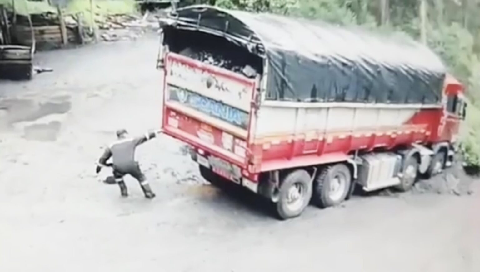 A super strong driver in Colombia appears to pull a massive truck from a muddy quagmire using just one hand, but a closer look reveals a colleague inside the cab assisting with steering and braking.