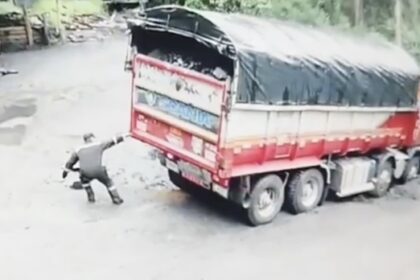 A super strong driver in Colombia appears to pull a massive truck from a muddy quagmire using just one hand, but a closer look reveals a colleague inside the cab assisting with steering and braking.