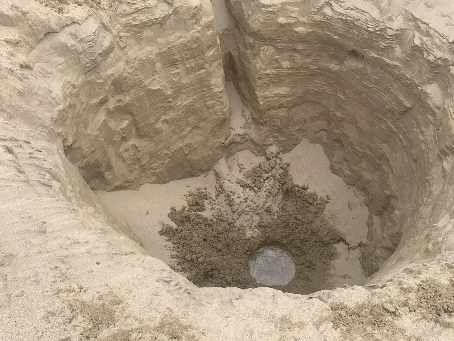 Fears for kids' safety as an 8ft deep hole is found on Tregirls beach, Cornwall. Locals alarmed; HM Coastguard warns of danger. Hole filled by digger to prevent accidents.