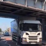 A trucker wedged his HGV under a 15ft 9in bridge near South Ruislip station, west London, despite clear height warnings. Traffic built up as locals filmed the aftermath.